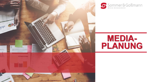 Mehrere Personen arbeiten an einem Tisch, auf dem ein Laptop, Dokumente, Diagramme, ein Taschenrechner und Notizbücher liegen.