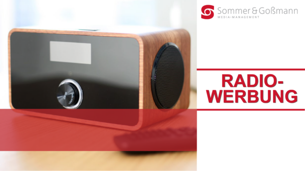 Moderner Lautsprecher mit Holzrahmen und schwarzer Vorderseite auf einem Tisch.