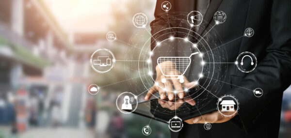 Eine Person in einem Anzug nutzt ein Tablet, um digitale Einkaufs- und Einzelhandelslösungen darzustellen. Um den Tablet-Bildschirm sind Symbole wie ein Einkaufswagen, Cloud-Services, Headset und Ladenfassaden in einem vernetzten, futuristischen Netzwerk angeordnet.